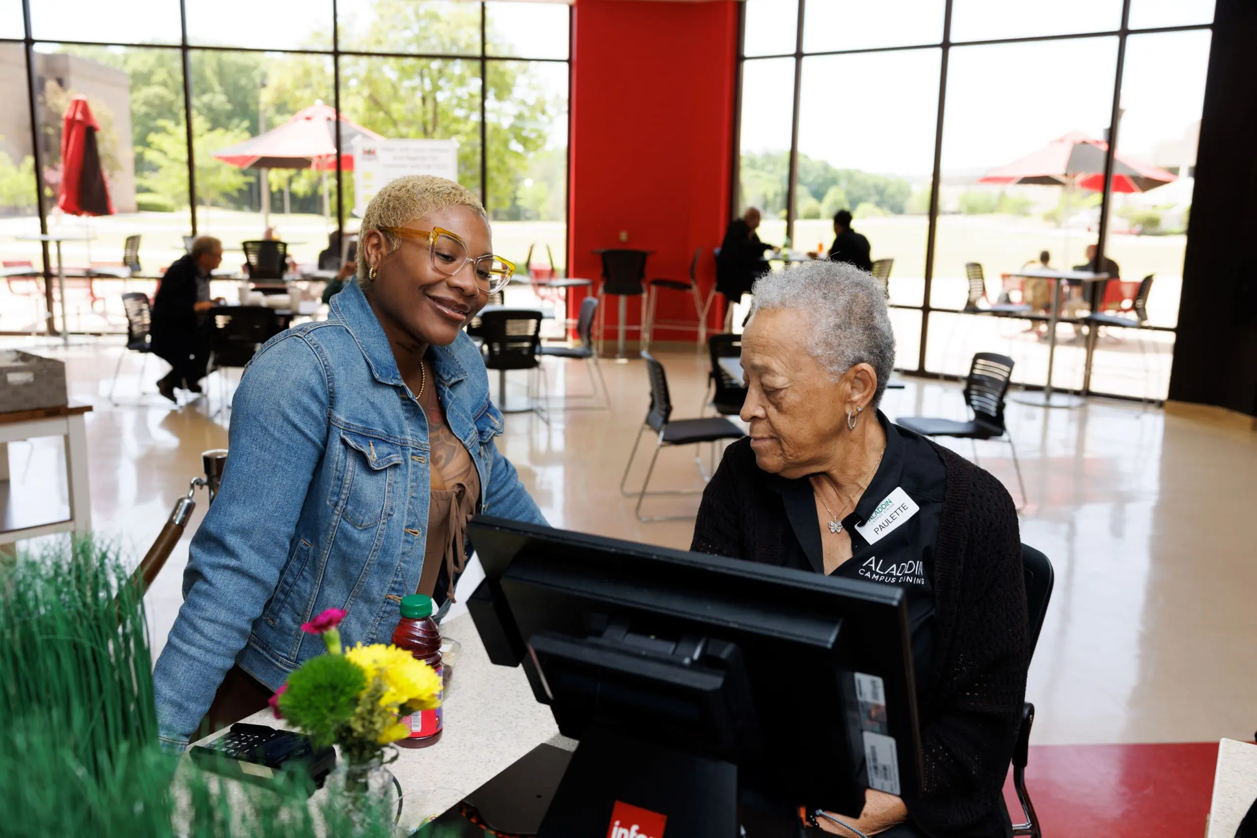 student smiling with dining staff