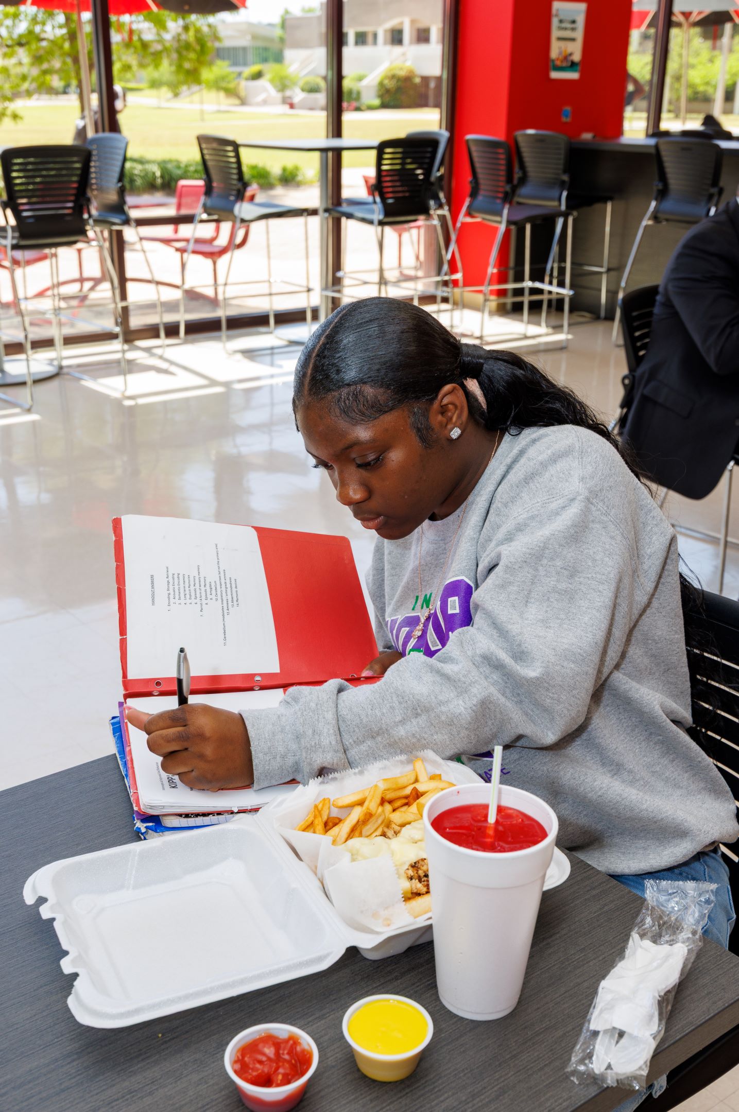 student studying while grabbing a bite to eat